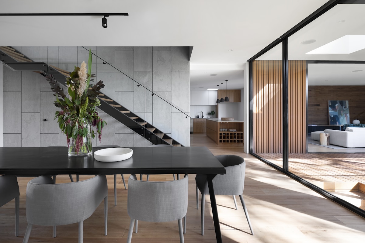 Contemporary dining area with a sculptural stair and glazing